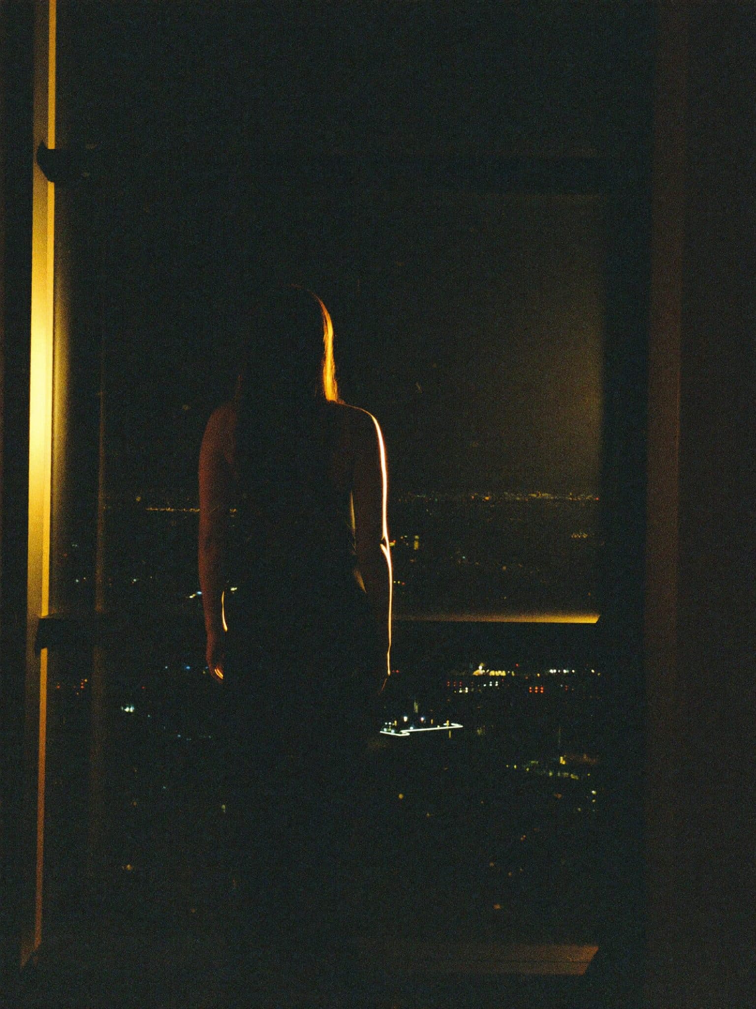 Silhouette of a creator overlooking a city at night